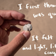 An image of a hand holding a gray piece of what looks like a rock. There's handwriting on top of the photo that says: "I first thought it was granite. It felt soft and light, like a crayon."